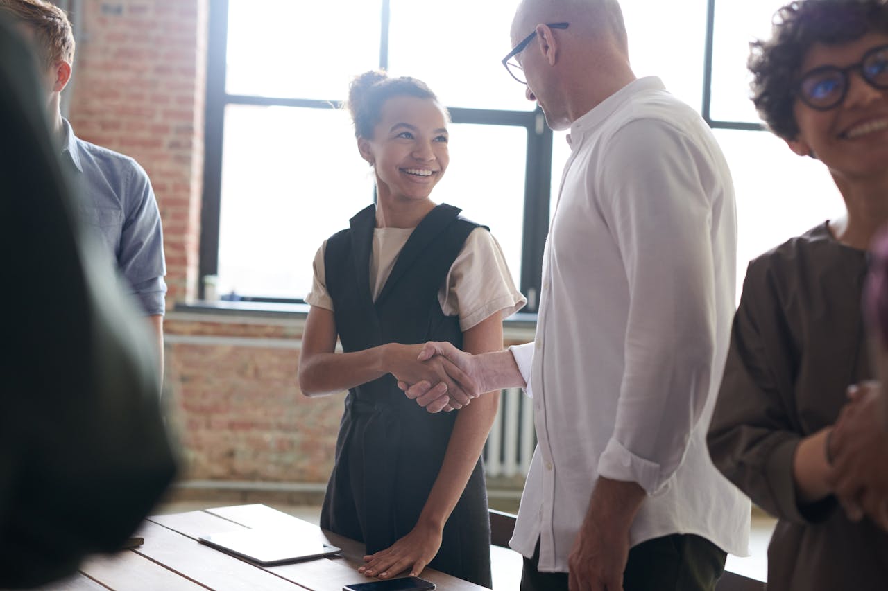 A diverse group exchanging a handshake in a bright, modern office environment.